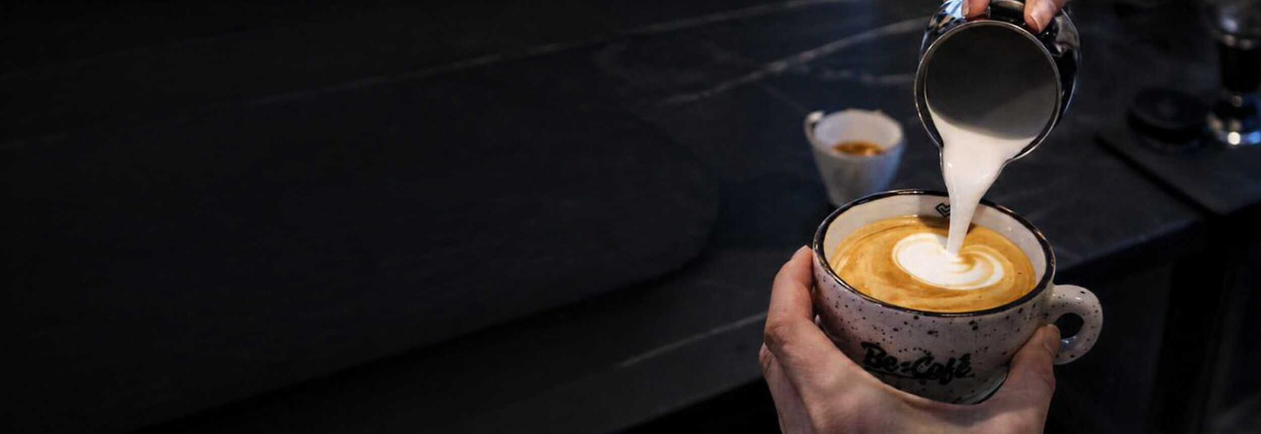 Barista nalieva mlieko do cappuccina v pražiarni Be:Café